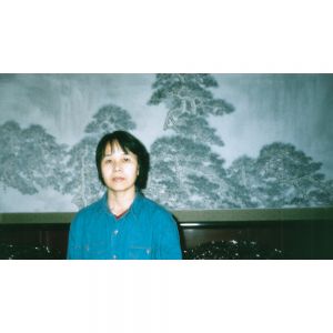 1995年天安门管理处收藏并在天安门城楼陈列展出杨炳湘创作的《万壑松风》丈二匹大幅国画。图为1995年杨炳湘在自己的作品前留影。